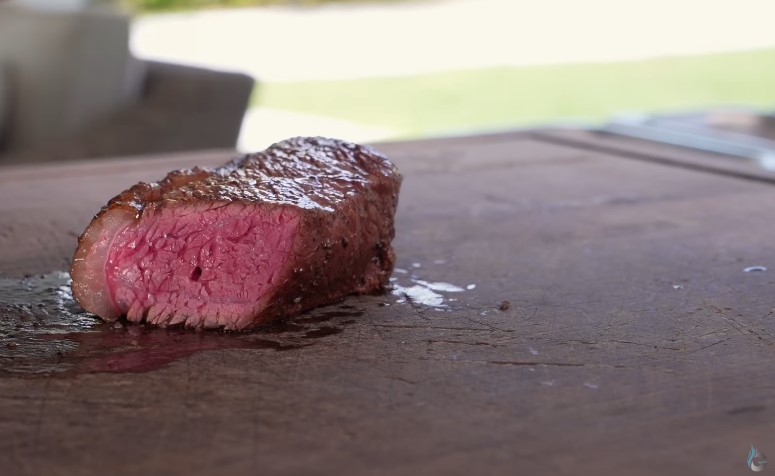 A juicy steak resting on a wooden cutting board